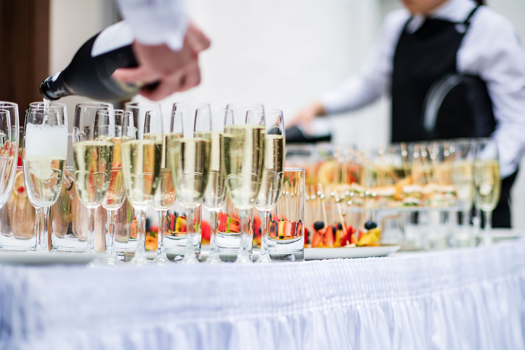 Stylish champagne glasses and food appetizers on table at weddin